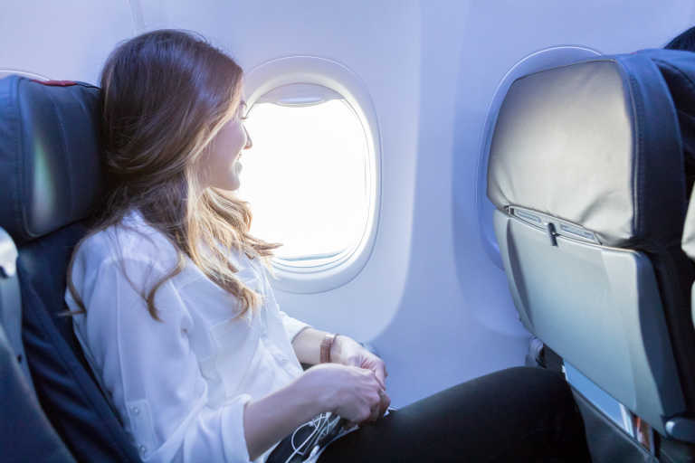 generic-woman-in-airplane-looking-window generic-woman-in-airplane-looking-window