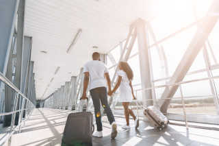 Generic Couple Walking With Suitcases In Airport Tiny 